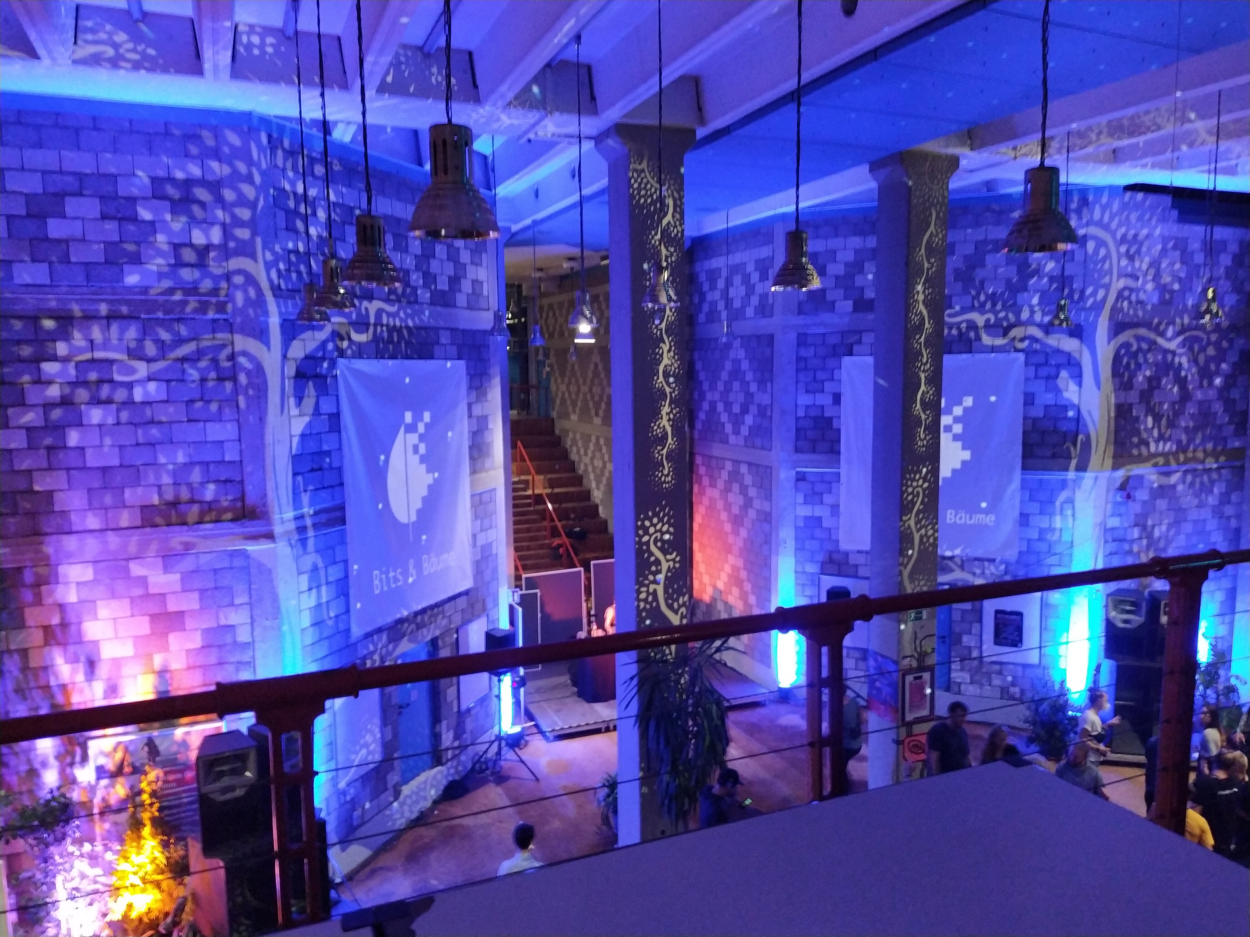Ein Treppenhaus in blauer Lichtstimmung. An die Wände werden Bäume projiziert.