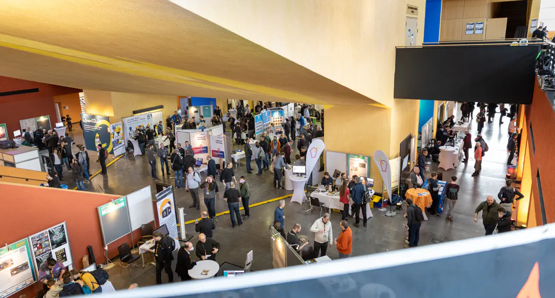 Linux-Tage Große Halle mit vielen Menschen von oben gesehen.
