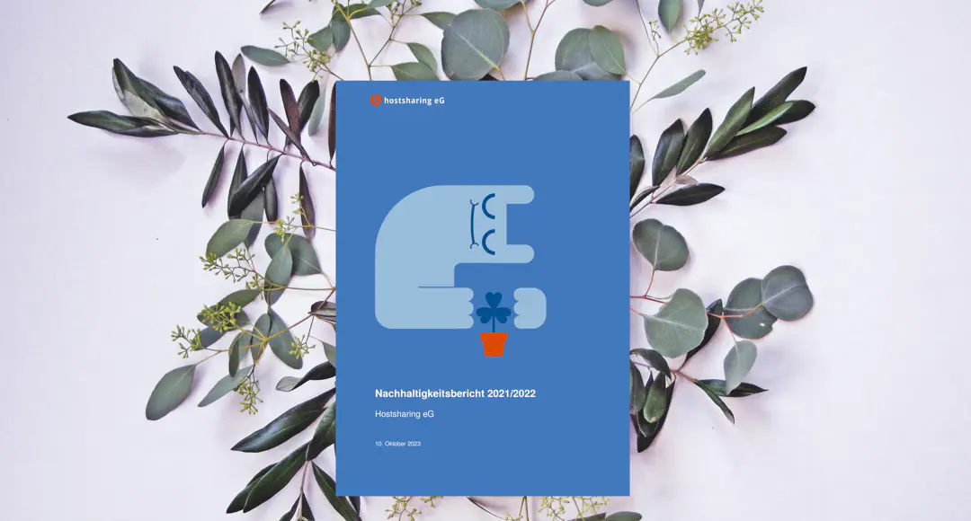 Der Nachhaltigkeitsbericht liegt auf fein arrangierten Blättern. Das Cover zeigt das Hostsharing-Maskottchen, das sich schützend über eine Blume beugt.