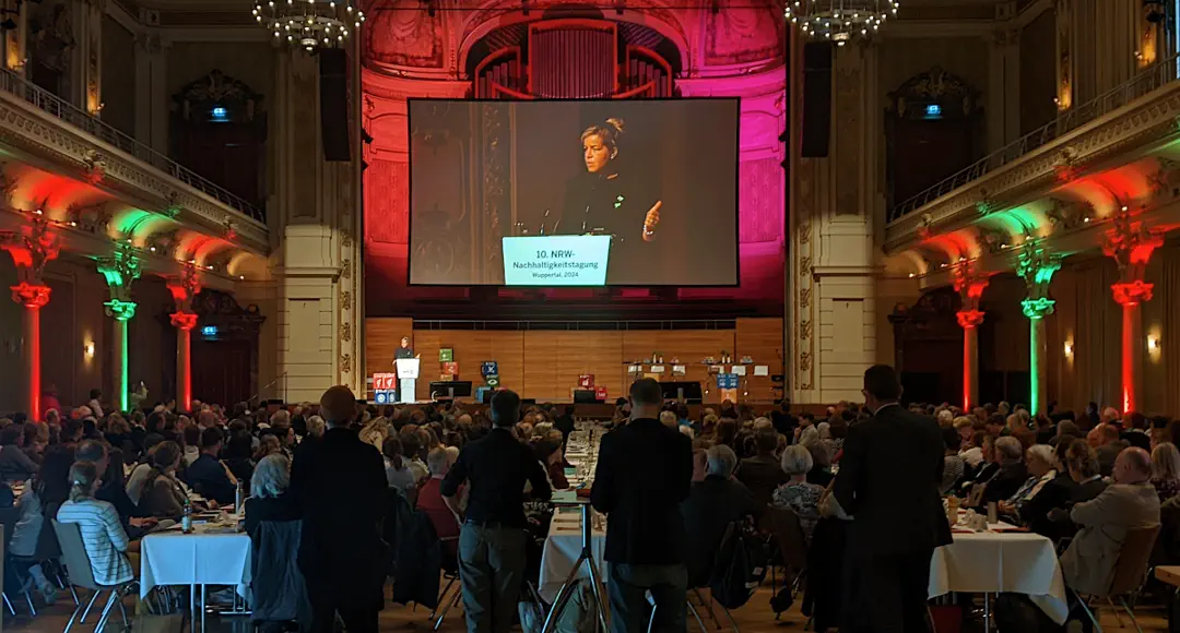 Großer Saal in der historischen Stadthalle Wuppertal. Auf der Bühne spricht Mona Neubaur.
