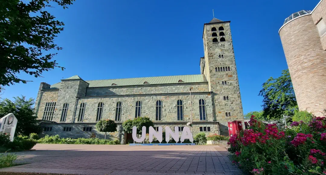 Schriftzug ›Unna‹ vor einer Kirche.