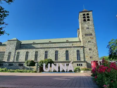 Schriftzug ›Unna‹ vor einer Kirche.