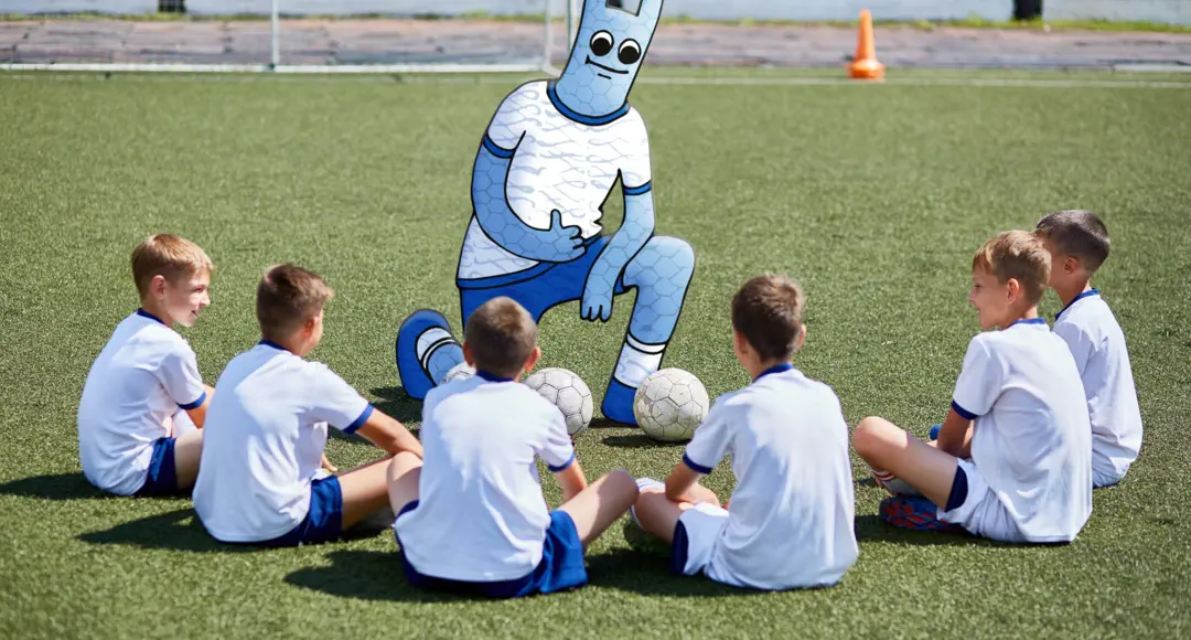 Eine Fußball-Mannschaft. Das Hostsharing-Maskottchen als Trainer.