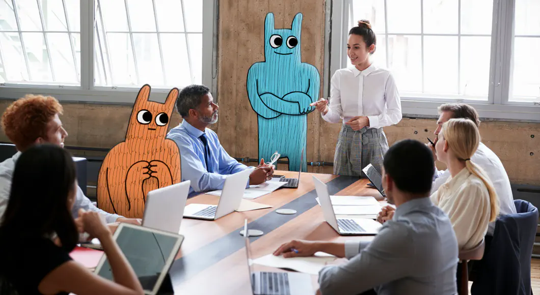 Das Hostingunternehmen an Ihrer Seite Ein Business-Meeting. Eine Frau erklärt etwas dem Team. Neben ihr steht das Hostsharing-Maskottchen. Ein zweites sitzt mit am Tisch.