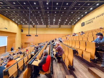 Ein großer Hörsaal ist etwa zu einem Drittel gefüllt.