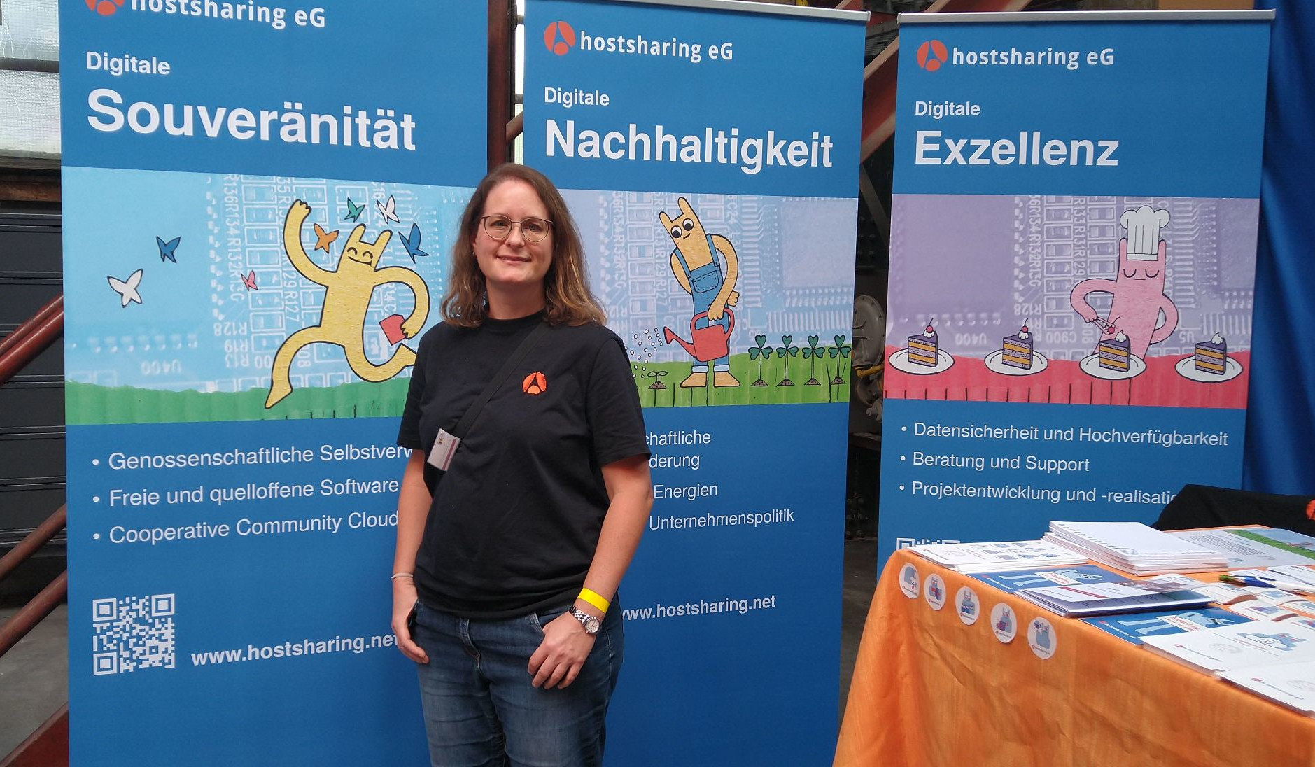 Eine Frau vor Plakat-Aufstellern, auf denen Digitale Souveränität, digitale Nachhaltigkeit und digitale Exzellenz zu lesen ist.