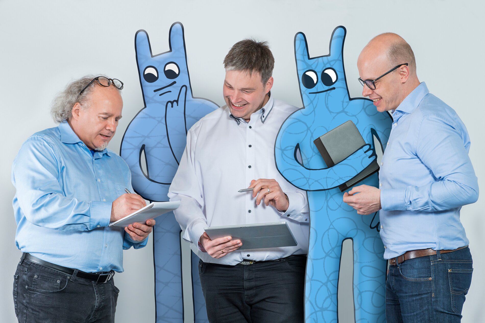 Drei Herren stehen mit zwei Hostsharing-Maskottchen zusammen und besprechen etwas.