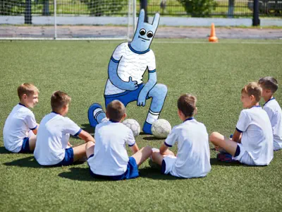 Das Hostsharing-Maskottchen steht wie ein Trainer vor einer Fußballjugendmannschaft.